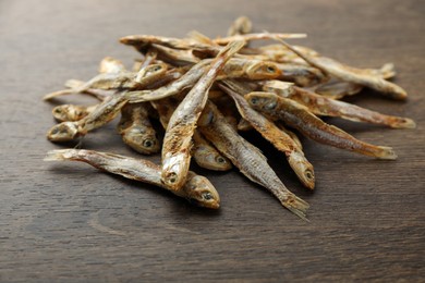 Delicious dried anchovies on wooden table, closeup