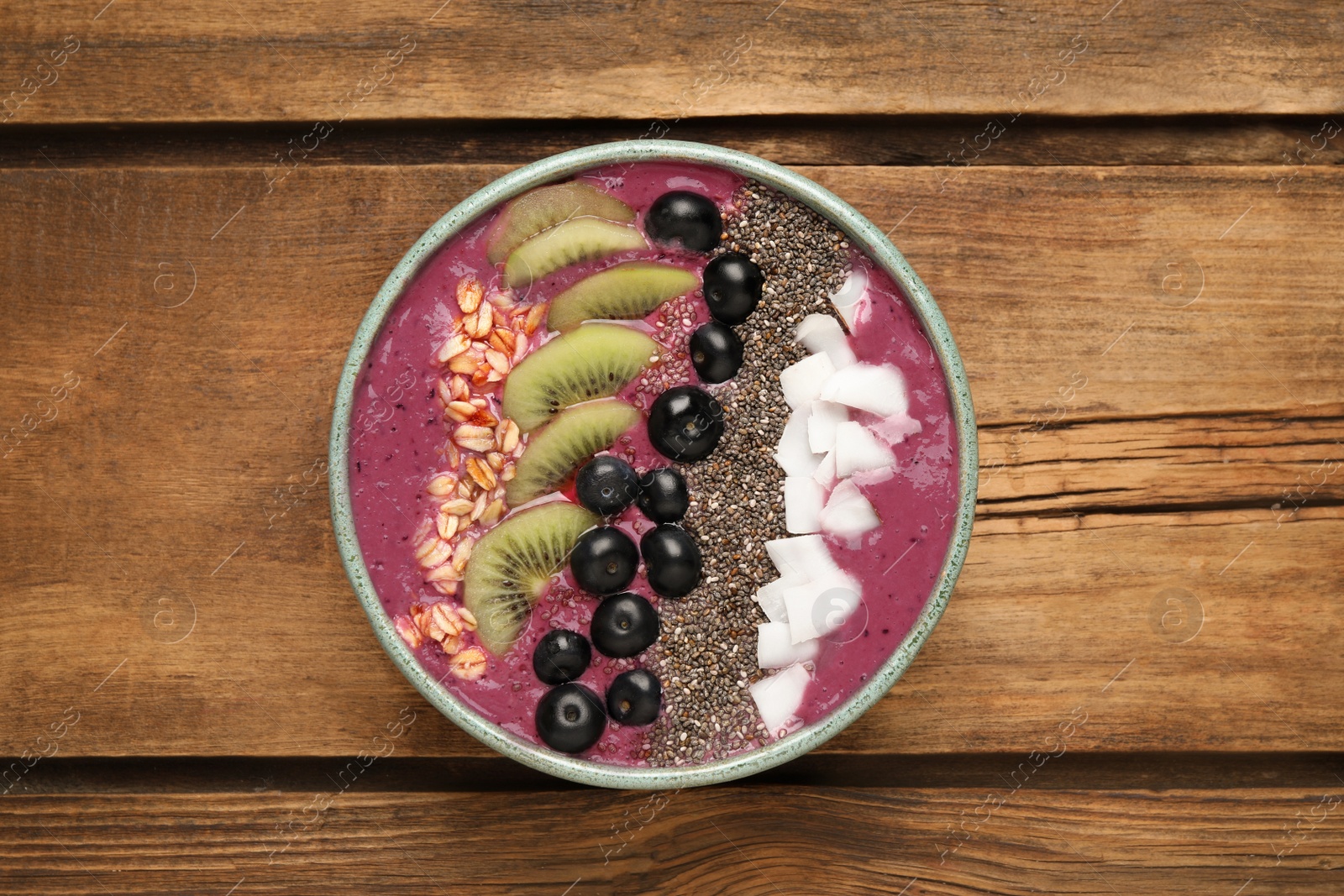 Photo of Healthy breakfast with delicious acai smoothie and fruits in bowl on wooden table, top view