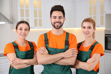 Team of professional janitors in kitchen. Cleaning service