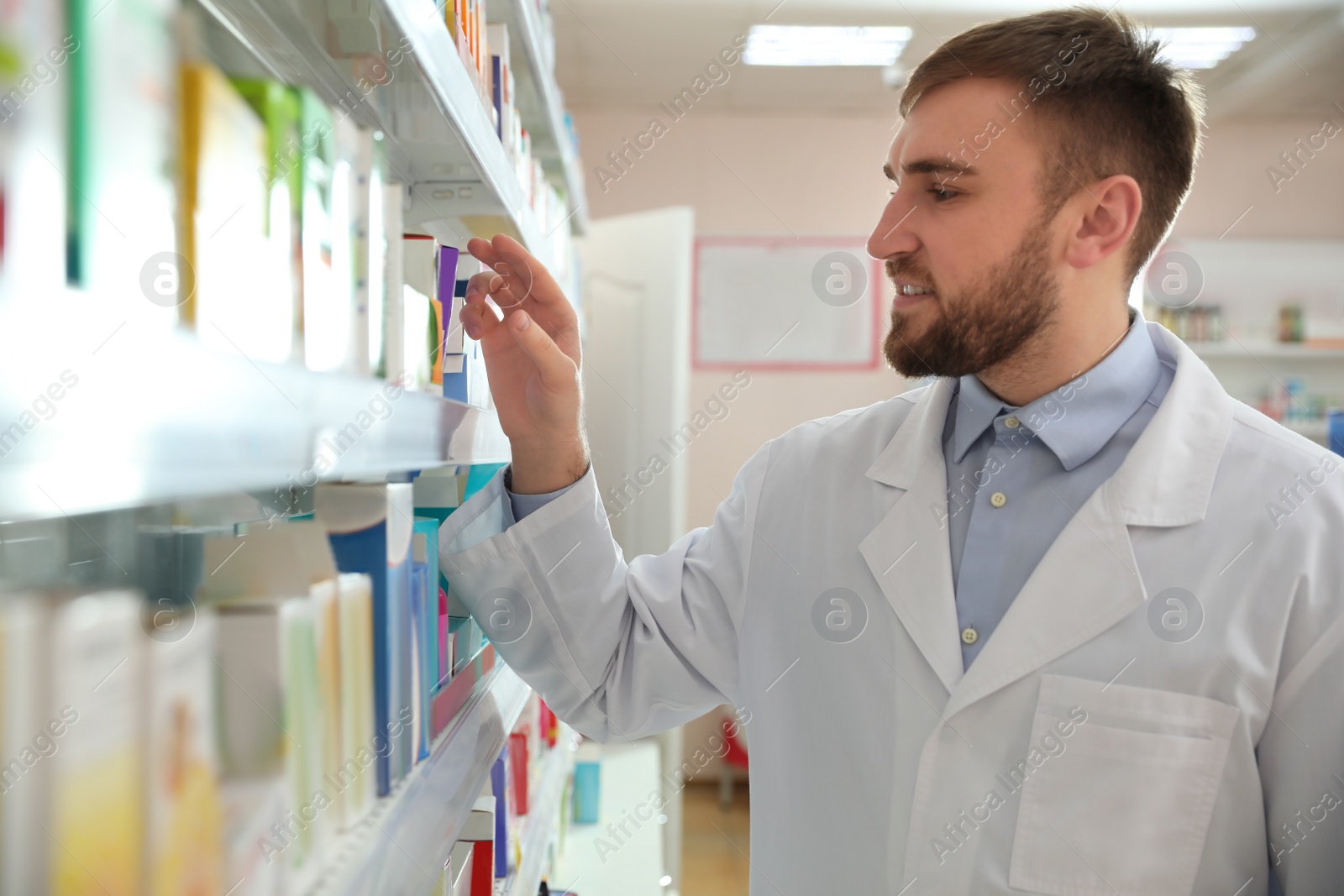 Image of Professional pharmacist near shelves in modern drugstore