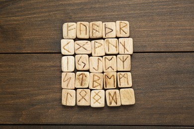 Runes with different symbols on wooden table, top view