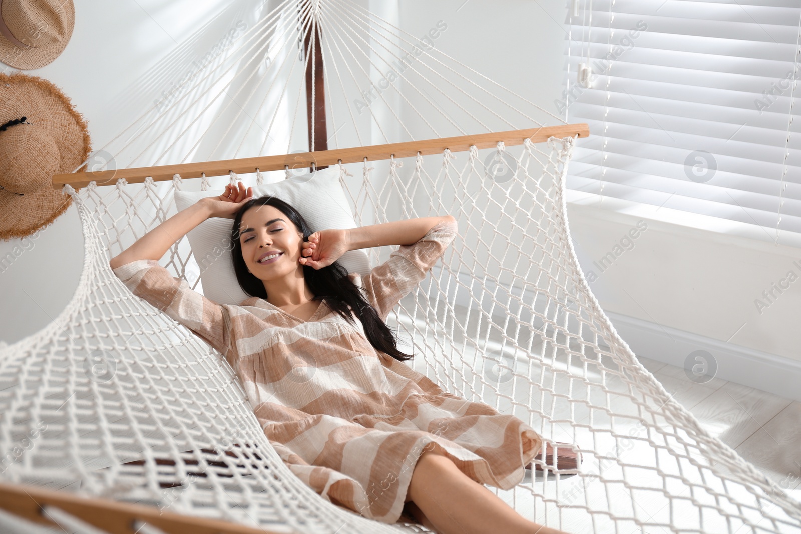 Photo of Young woman relaxing in hammock at home