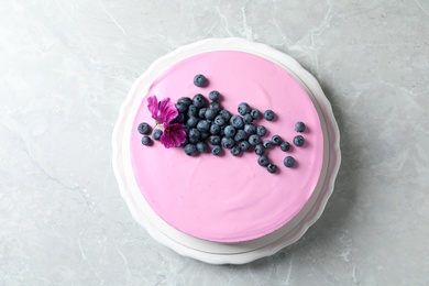 Photo of Plate with tasty blueberry cake on light grey table, top view