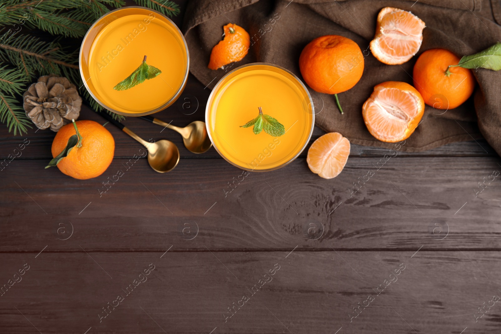 Photo of Delicious tangerine jelly and fresh fruits on brown wooden table, flat lay. Space for text