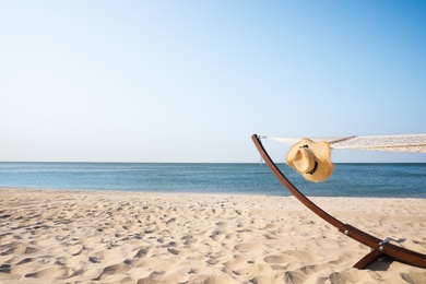 Photo of Hammock and hat at seaside. Time to relax