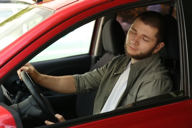 Tired man sleeping in his modern car