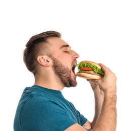 Young man eating tasty burger on white background