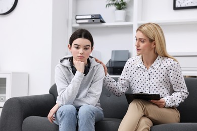 Psychologist working with teenage girl in office