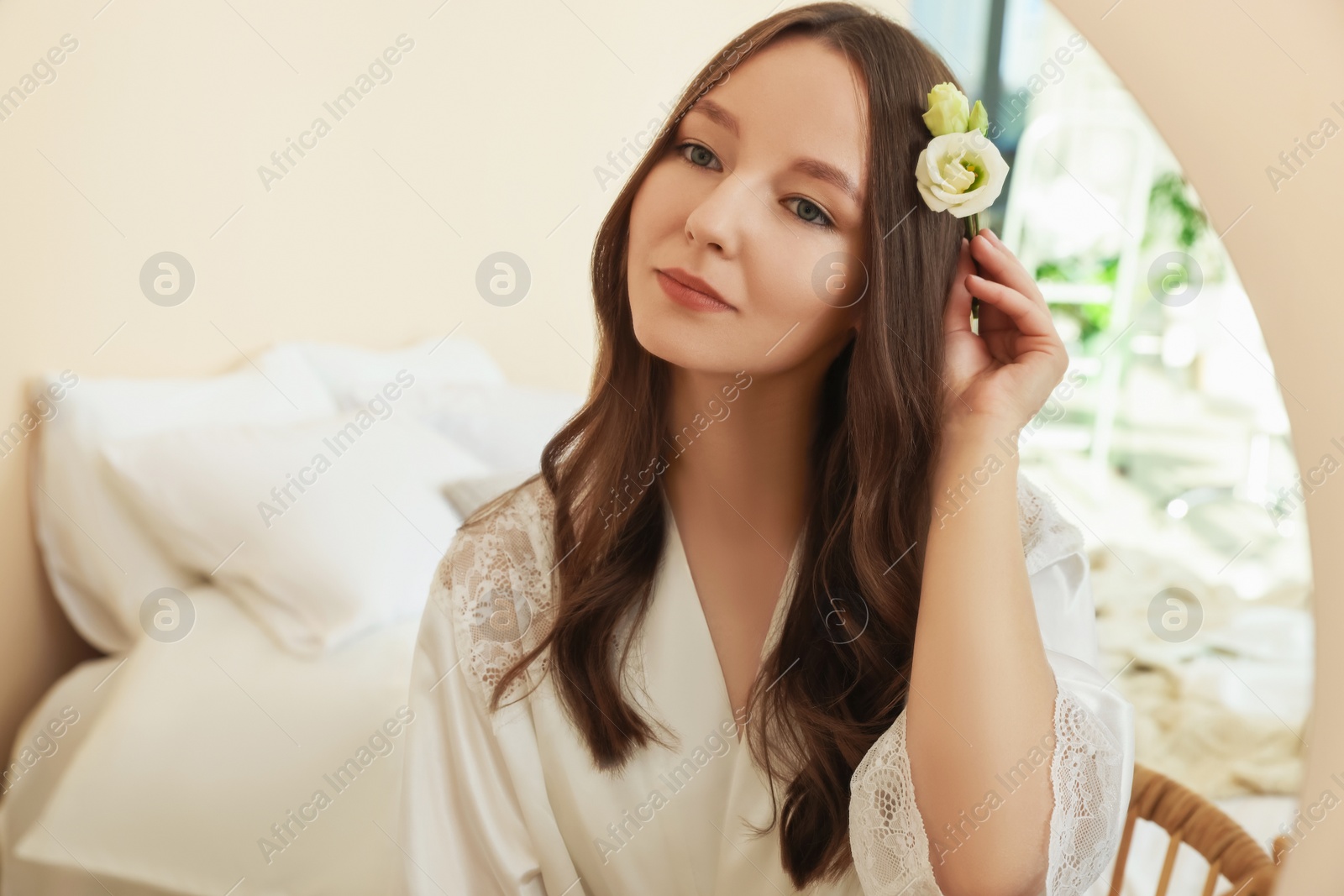 Photo of Beautiful young bride near mirror in room. Wedding day