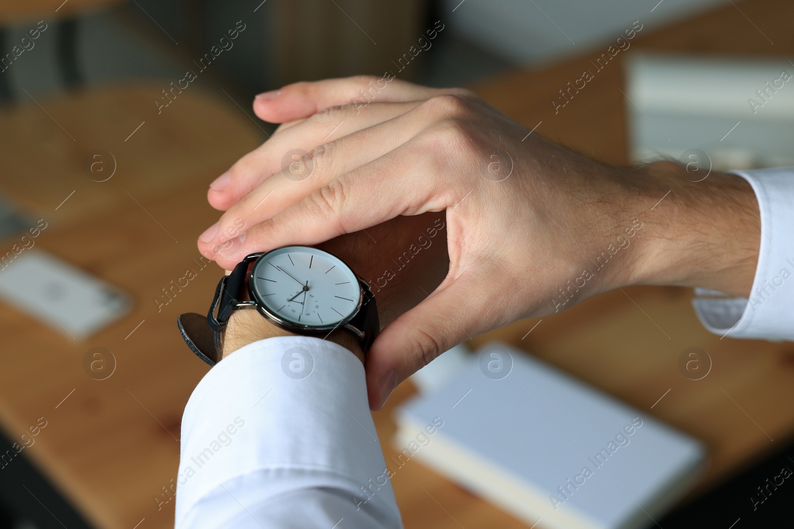 Photo of Man checking time in office, closeup. Being late