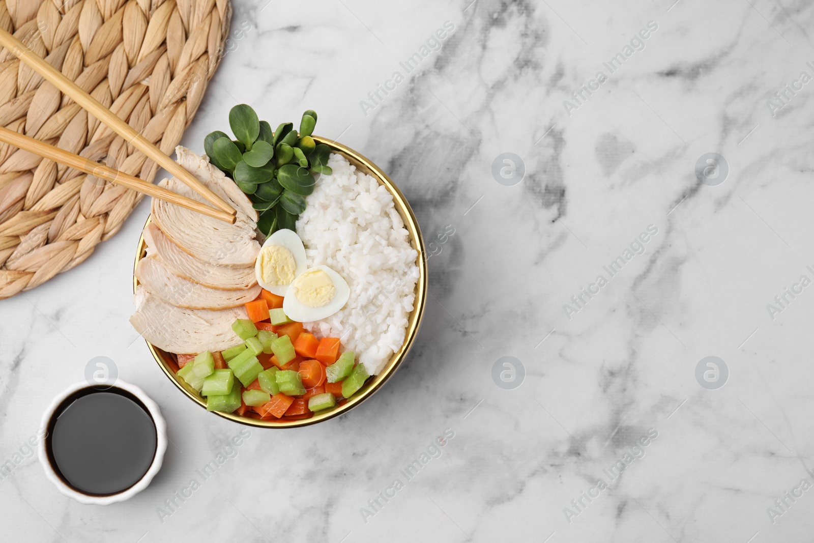 Photo of Delicious poke bowl of meat, egg, rice and vegetables served with soy sauce on white marble table, flat lay. Space for text
