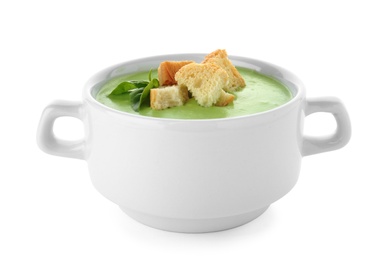 Photo of Green pea soup with croutons in bowl on white background