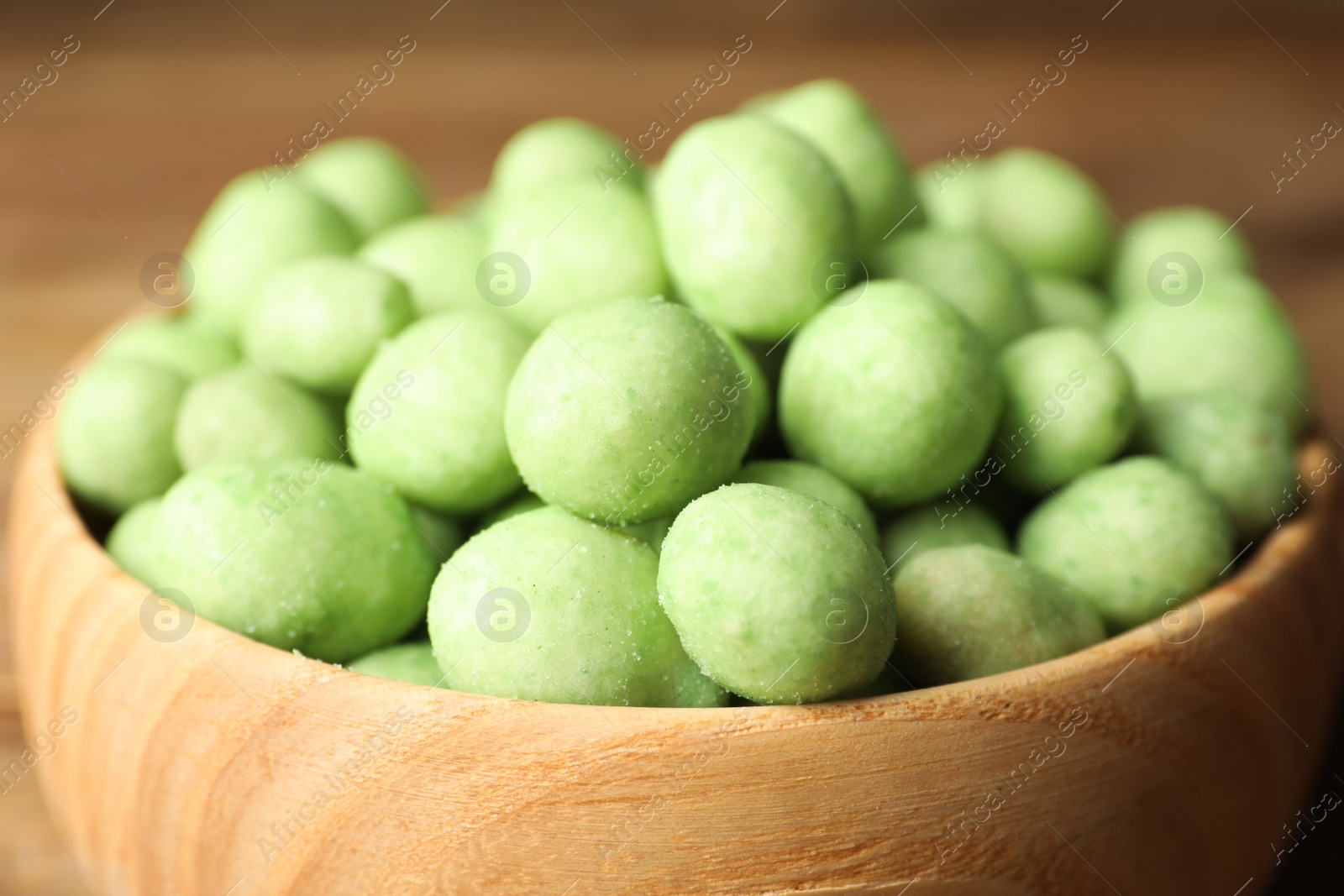 Photo of Tasty wasabi coated peanuts in bowl, closeup