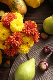 Photo of Autumn flat lay composition with beautiful chrysanthemum flowers and pumpkins on wooden table