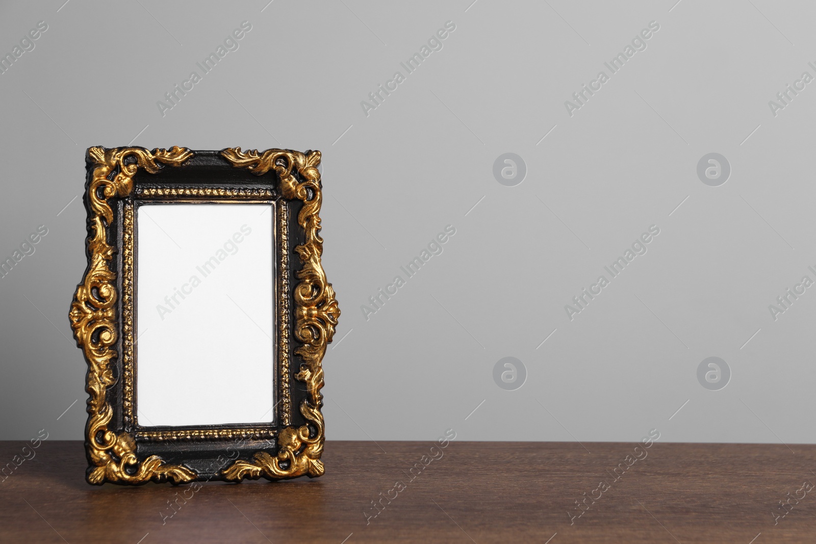 Photo of Beautiful vintage empty frame on wooden table, space for text