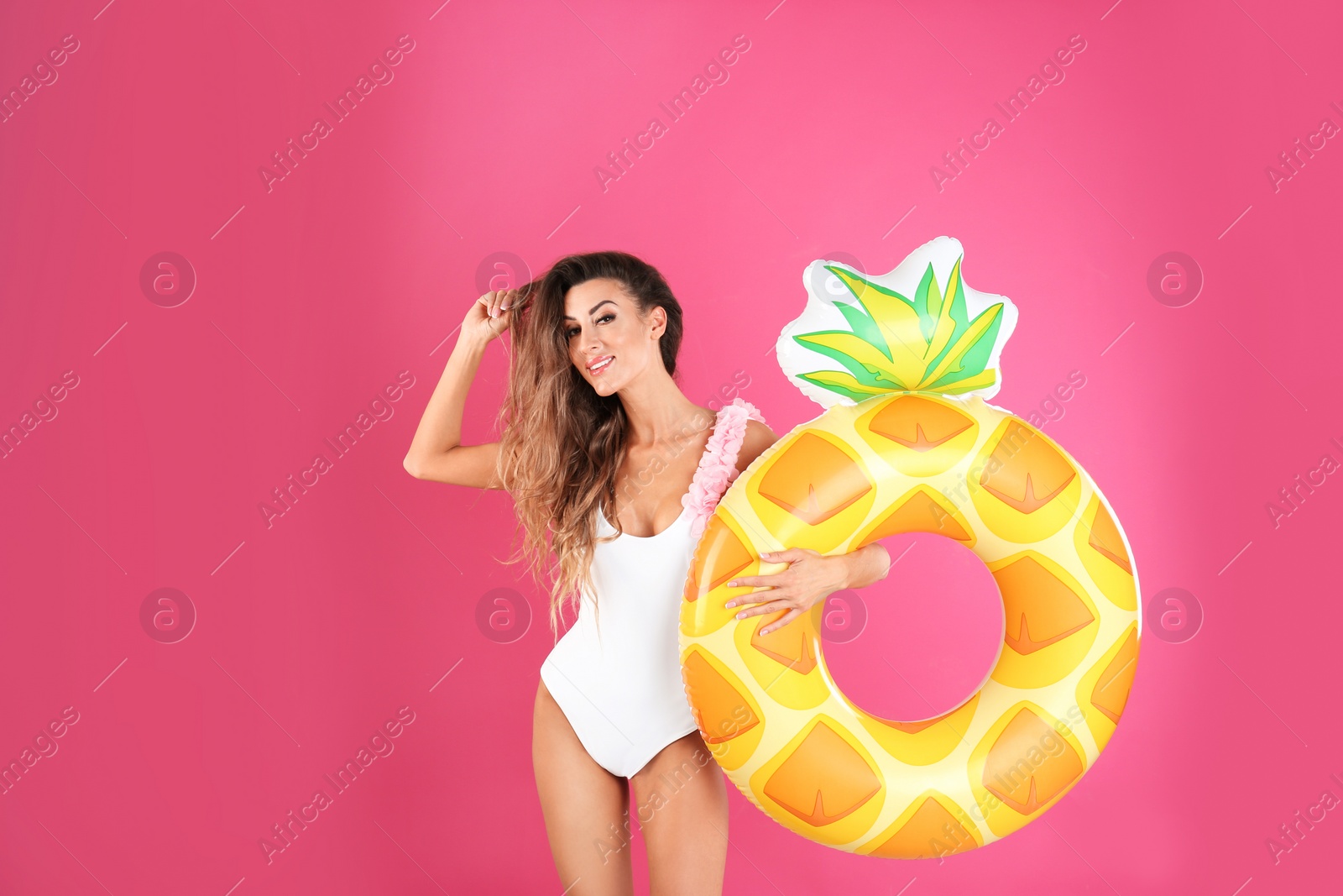 Photo of Pretty sexy woman in stylish bikini with inflatable ring on color background