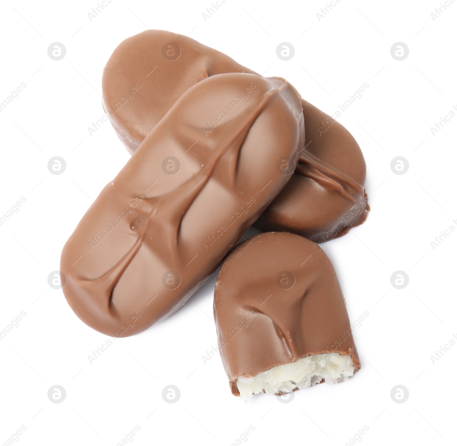 Photo of Delicious milk chocolate candy bars with coconut filling on white background, top view