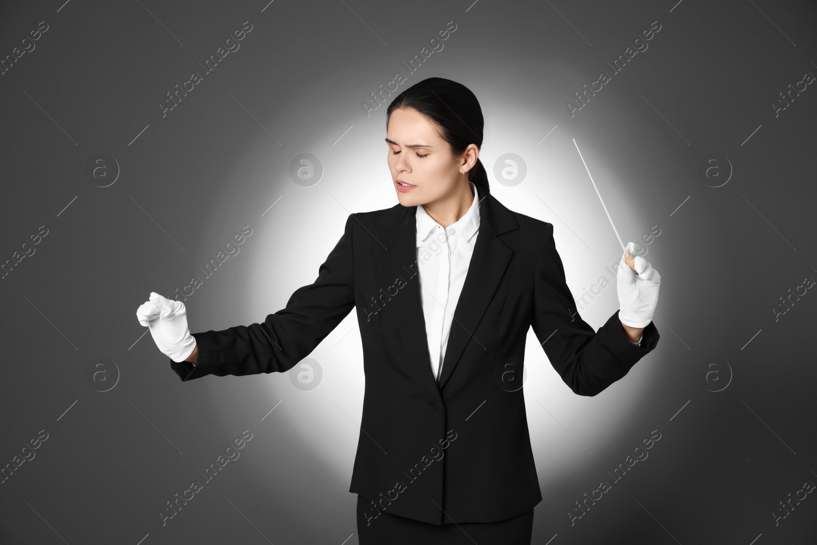 Photo of Professional conductor with baton on grey background