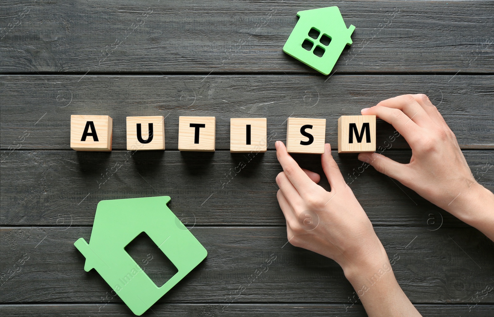 Photo of Woman with cubes on wooden background. Autism concept