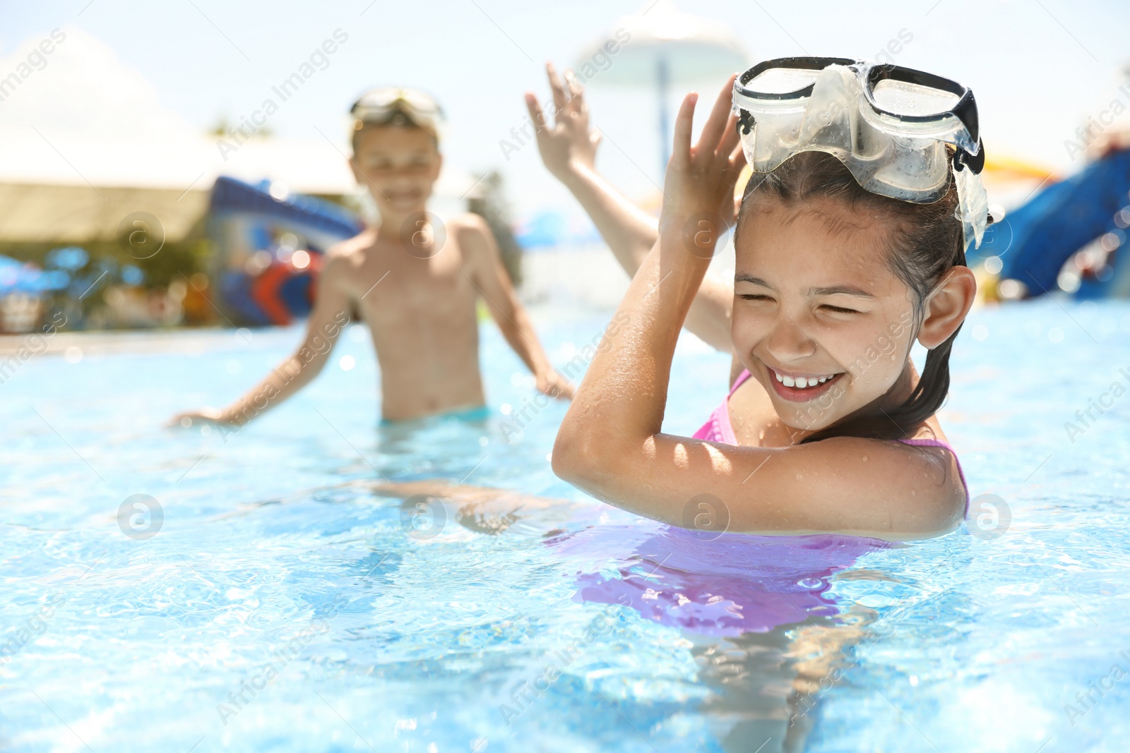 Photo of Little children having fun in swimming pool. Summer vacation