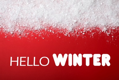 Image of Greeting card. Snow near text Hello Winter on red background, top view