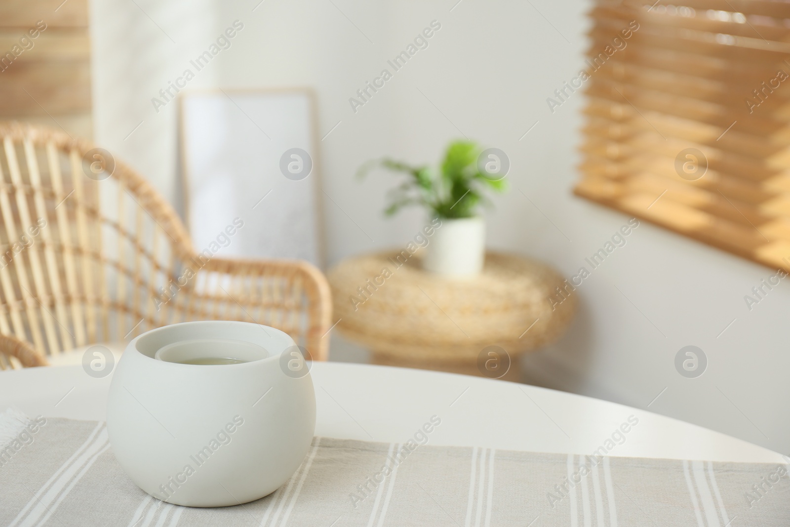 Photo of Wax air freshener on table in room, space for text. Cozy interior