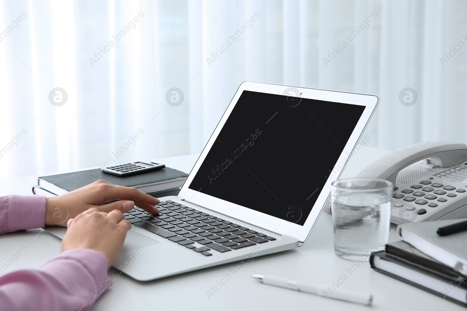 Photo of Young woman using modern laptop at table, closeup