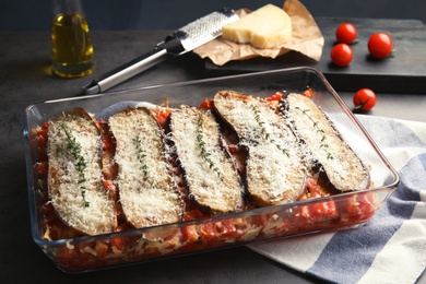 Photo of Baked eggplant with tomatoes and cheese in dishware on table