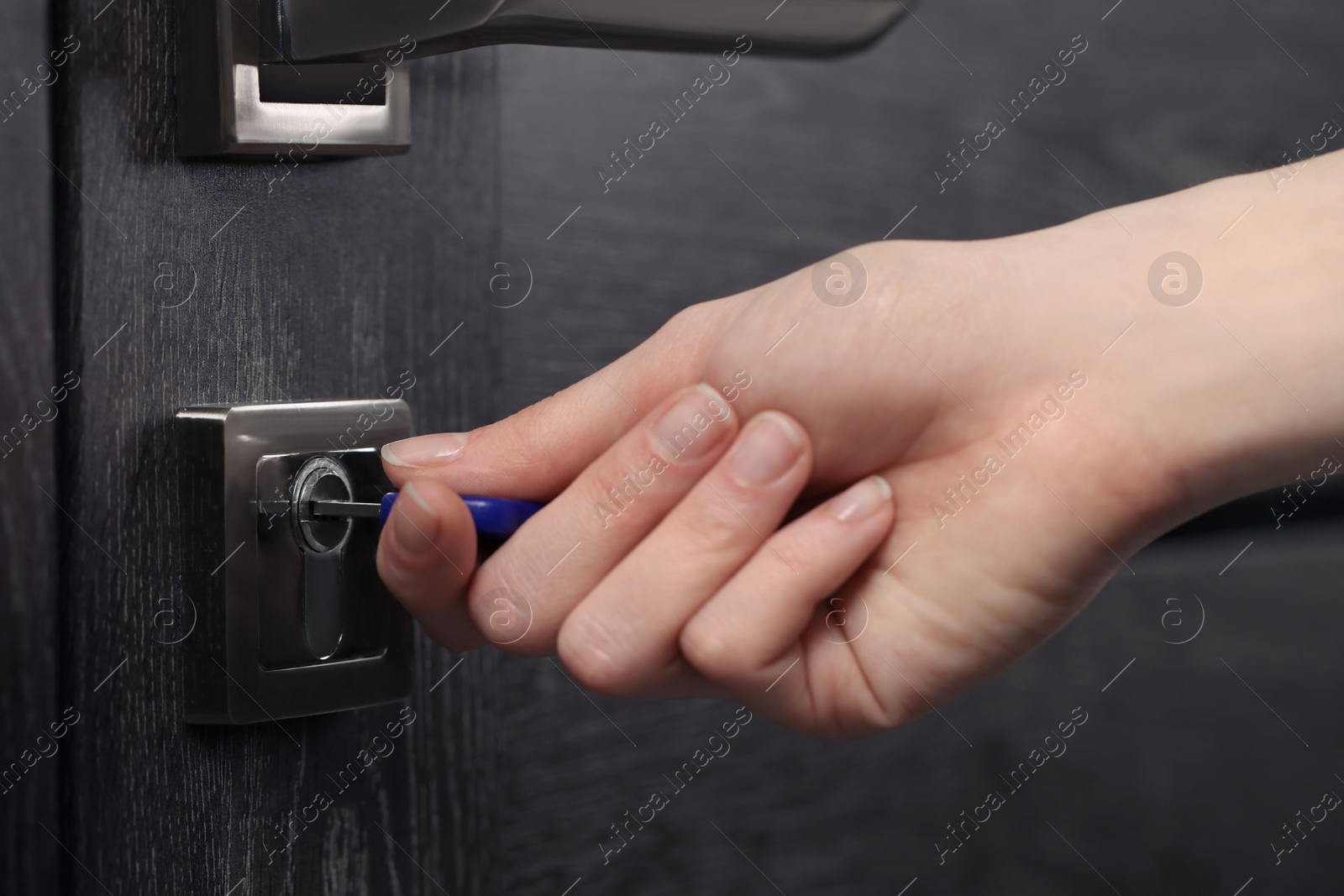 Photo of Woman unlocking door with key, closeup view