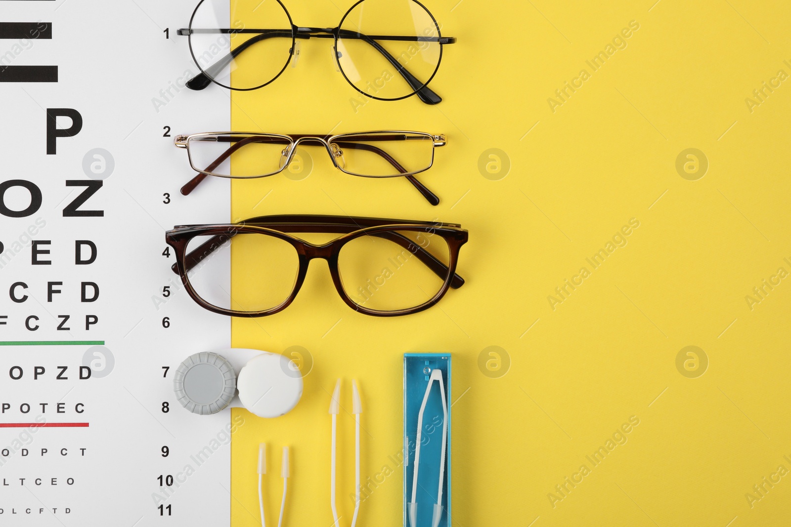 Photo of Vision test chart, glasses, lenses and tweezers on yellow background, flat lay. Space for text