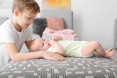 Cute boy playing with little baby at home