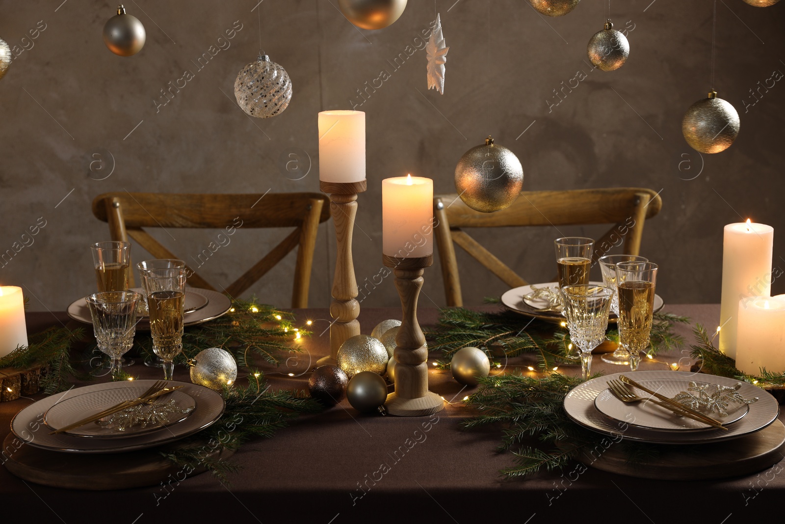 Photo of Christmas table setting with burning candles and festive decor