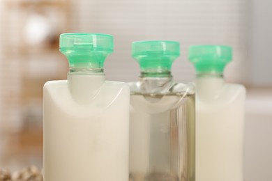 Photo of Mini bottles of cosmetic products on blurred background, closeup