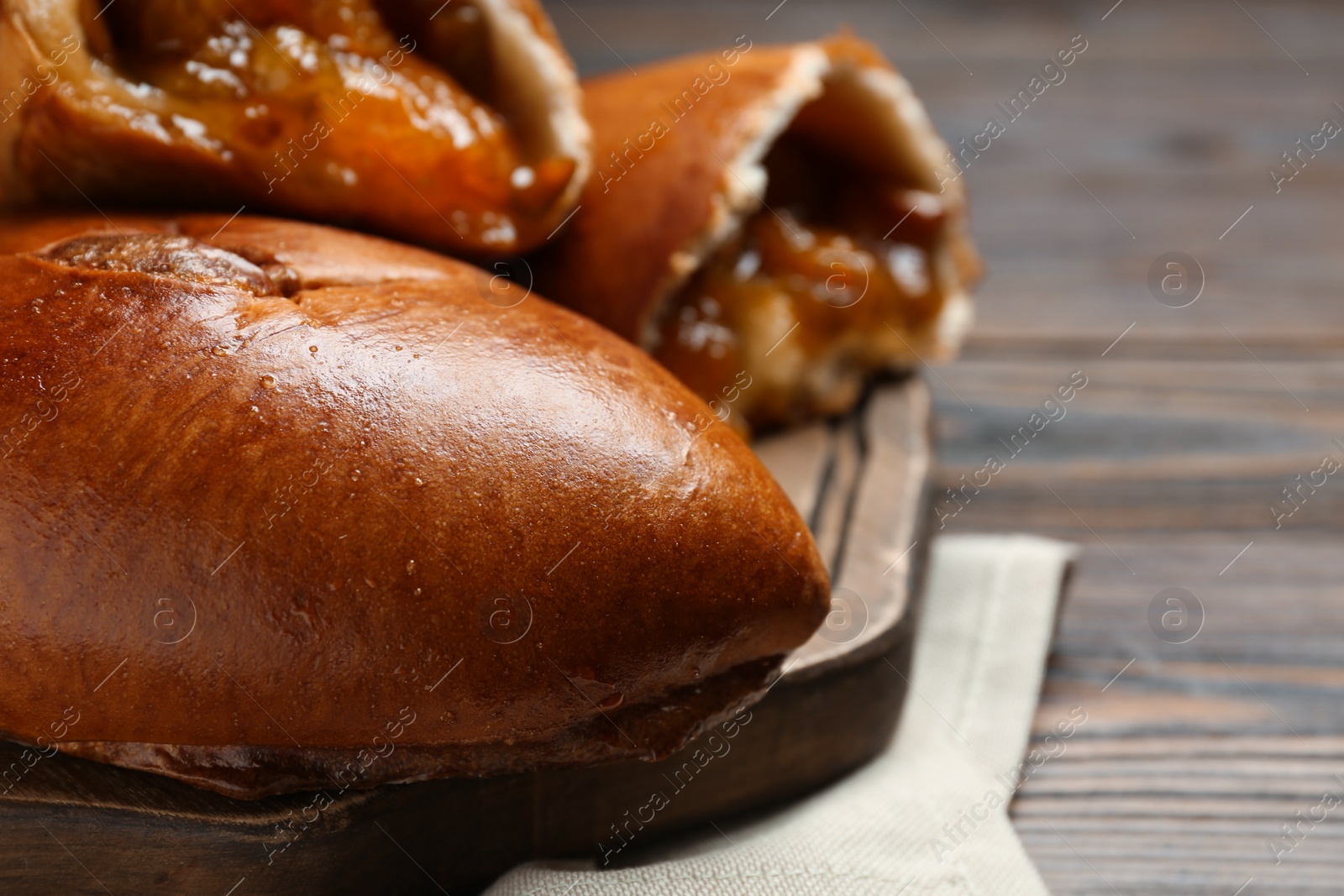 Photo of Delicious baked patties on wooden table, closeup. Space for text