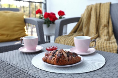 Photo of Outdoor breakfast with tea and croissants on white table on terrace