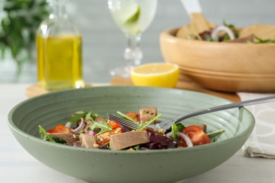 Photo of Delicious salad with beef tongue, vegetables and fork served on white table, closeup