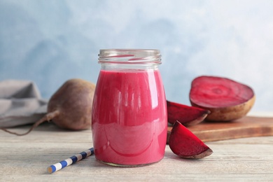 Photo of Jar with healthy detox smoothie and beet on table