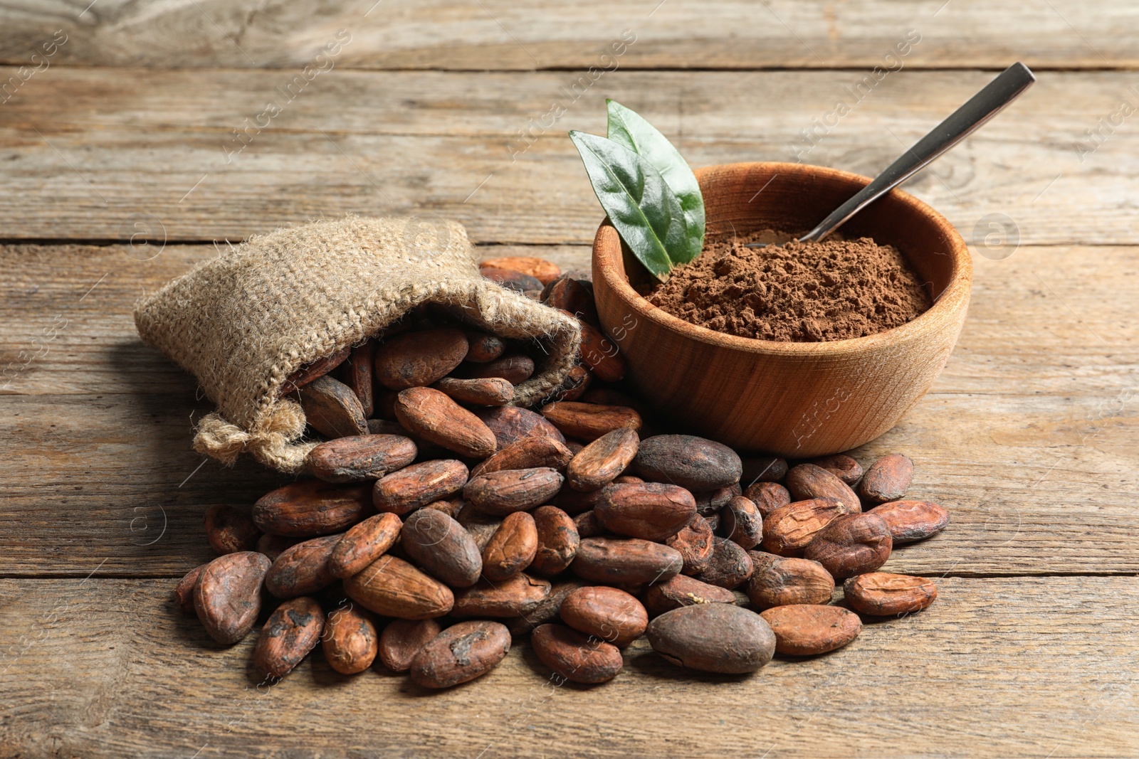 Photo of Composition with cocoa beans and powder on wooden table