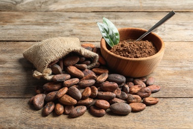 Photo of Composition with cocoa beans and powder on wooden table