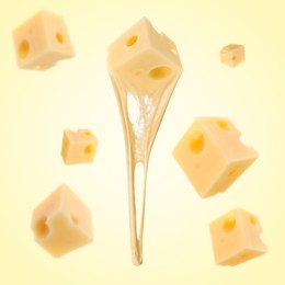 Pieces of cheese falling on yellow background