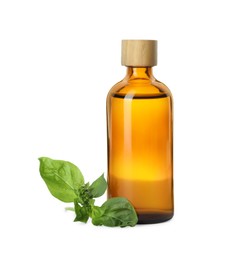 Photo of Bottle of essential oil and basil on white background