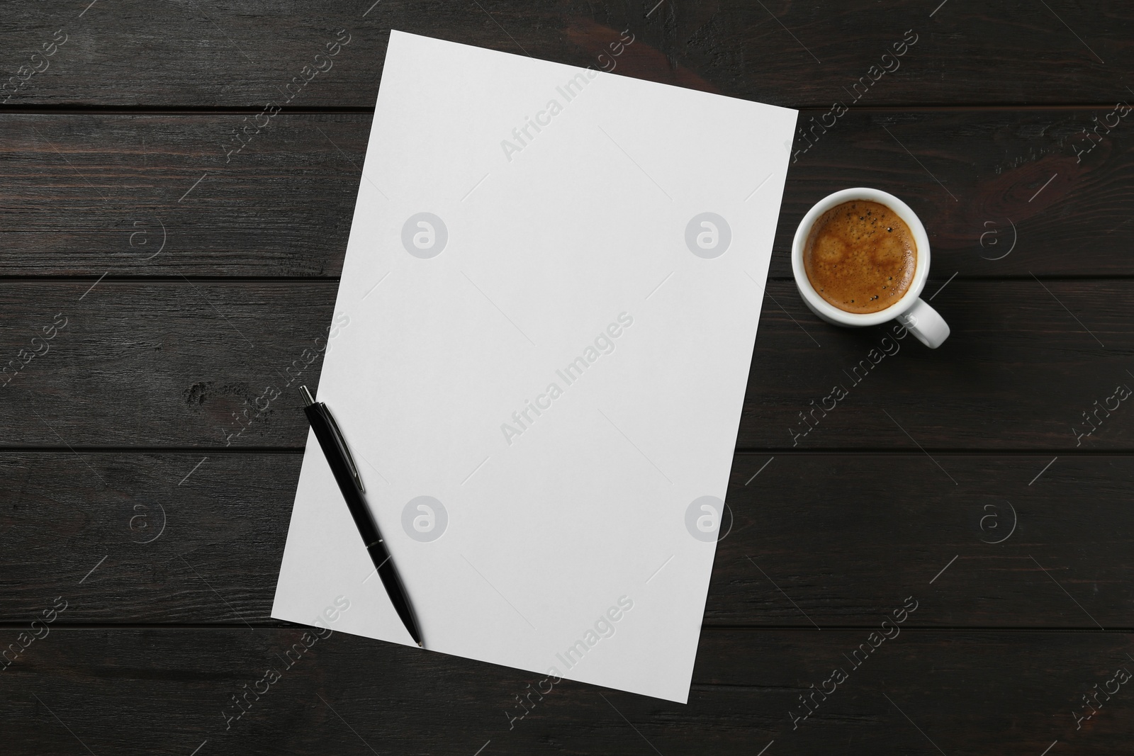 Photo of Blank paper sheet, pen and cup of coffee on black wooden table, flat lay. Space for text