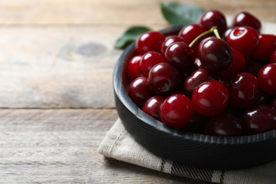 Photo of Sweet juicy cherries on wooden table, closeup. Space for text
