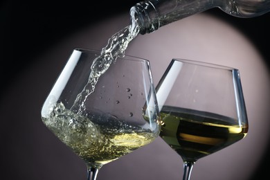 Photo of Pouring tasty aromatic wine in glass on gray background, closeup