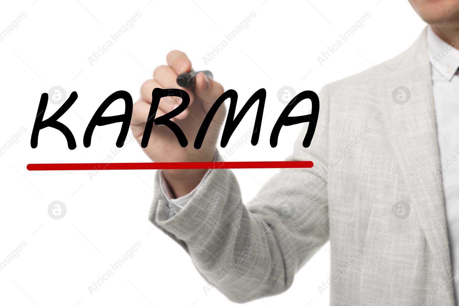 Image of Man writing word KARMA on glass against white background, closeup