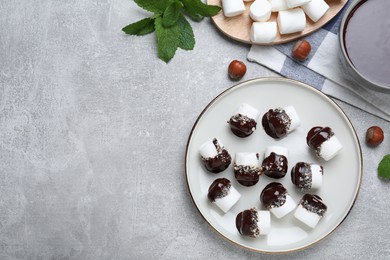 Photo of Delicious marshmallows covered with chocolate on light grey table, flat lay. Space for text