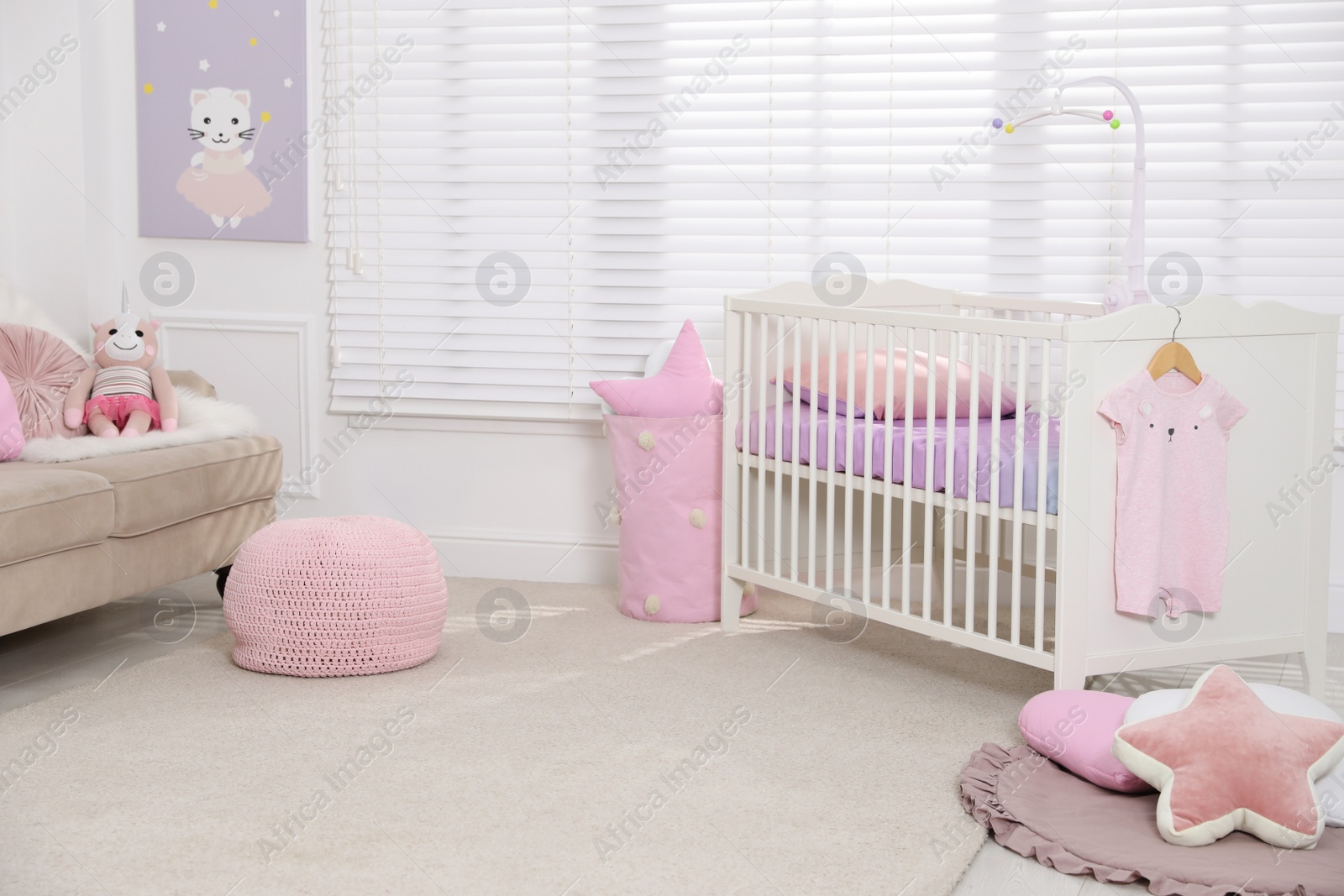 Photo of Cozy baby room with crib and sofa. Interior design