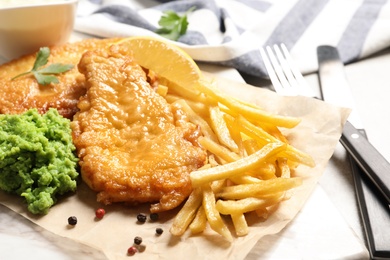 Photo of British traditional fish and potato chips on table