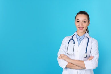 Young medical student in uniform on color background. Space for text