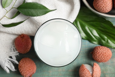 Photo of Fresh lychee juice and fruits on blue wooden table, flat lay